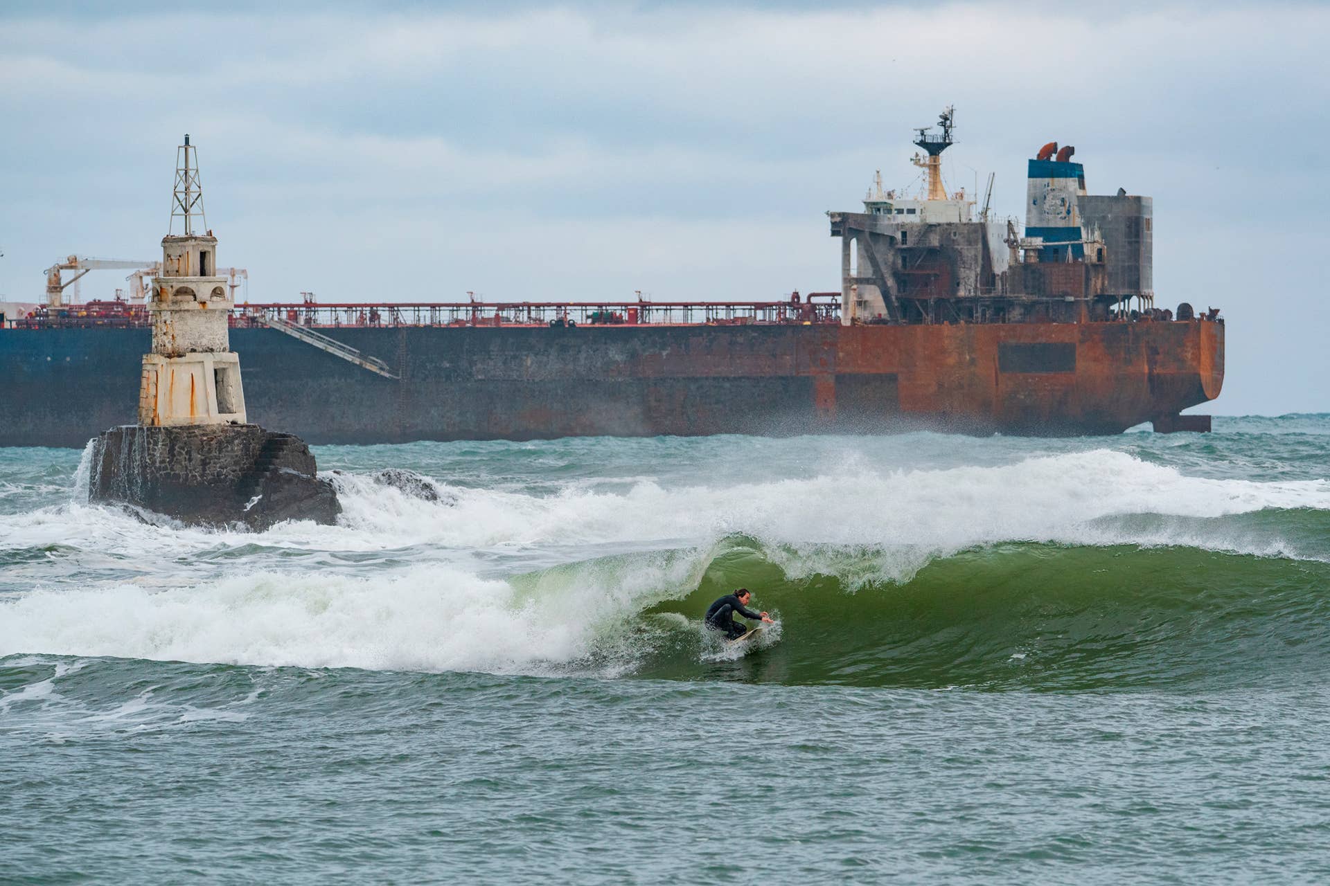 Ivo Taralezhkov surfing near a ghost ship