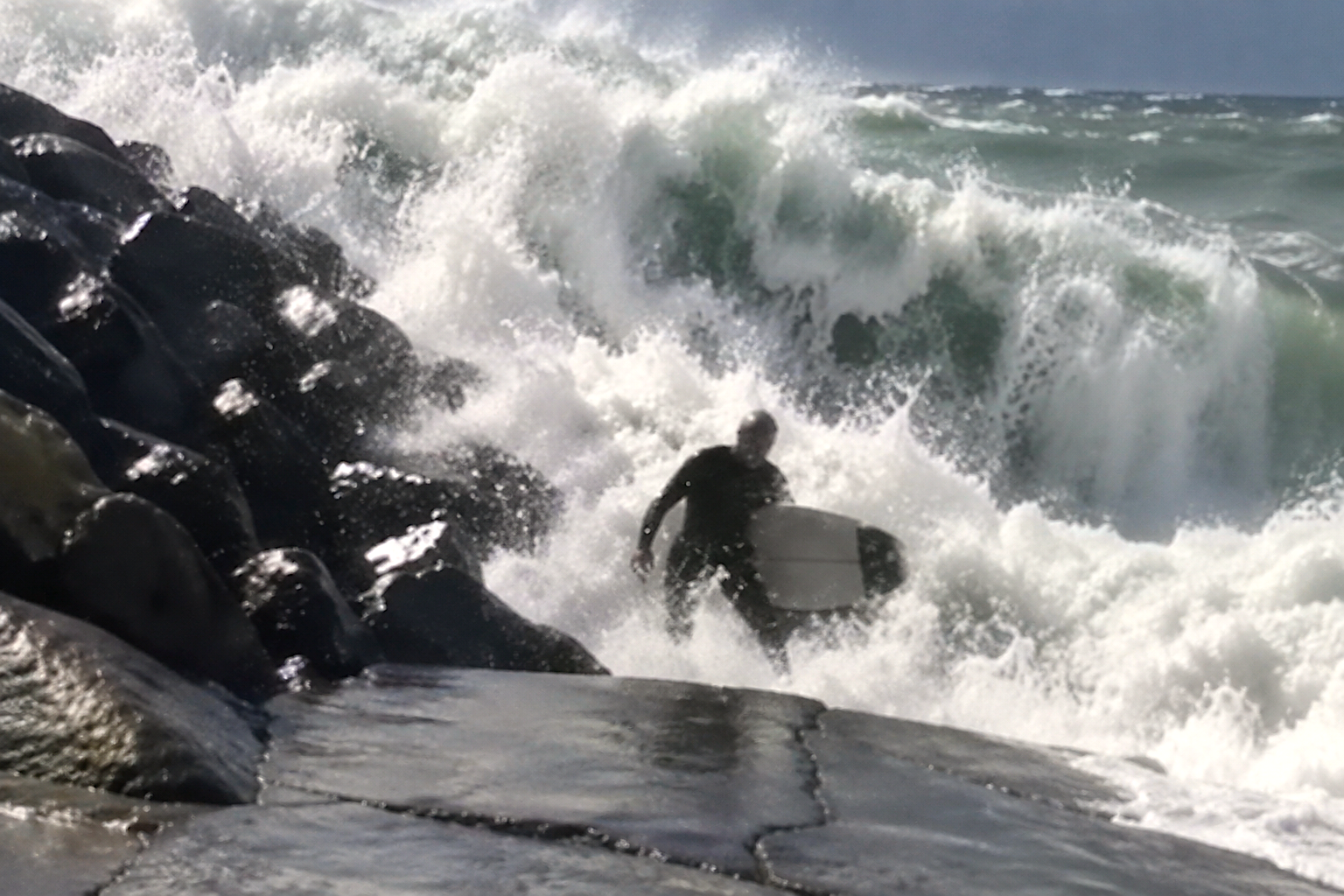 Massive Hurricane Swell Slams Surfer Into Oceanside Rocks, Knocks Him Out (Video)